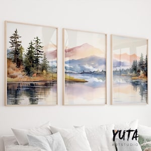 May include: A set of three watercolor paintings depicting a lake scene with mountains in the background. The first painting shows a group of trees reflected in the water. The second painting shows a lake with mountains in the background. The third painting shows a lake with mountains in the background and a group of trees on the shore.