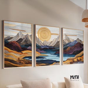 May include: Three abstract landscape paintings with a geometric mountain and lake design. The paintings are framed in wood and have a gold, blue, purple, and brown color scheme.