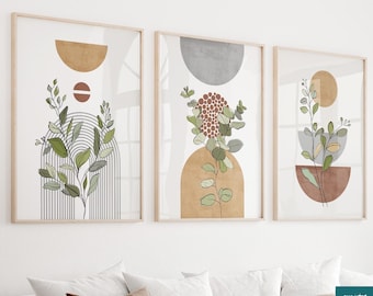 Puede incluir: Tres impresiones artísticas enmarcadas con diseños botánicos abstractos. Cada impresión presenta una composición minimalista con formas geométricas en tonos neutros, acentuada por ilustraciones de plantas verdes y marrones. Los marcos son de madera clara.