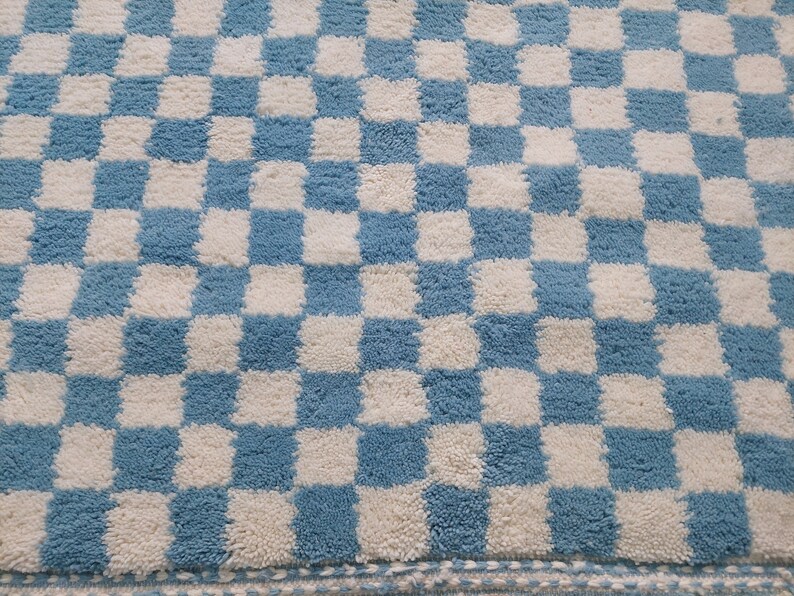 May include: A blue and white checkered bath mat with a fluffy texture.
