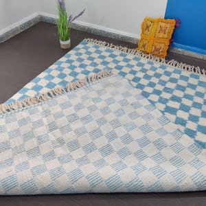 May include: Two blue and white checkered rugs with a fringe border. The rugs are made of a soft, fluffy material and are perfect for adding a touch of style to any room.