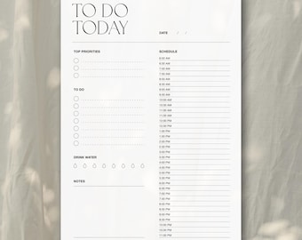Puede incluir: Un planificador blanco "TO DO TODAY" con secciones para prioridades, lista de tareas y horario. Incluye una sección "Drink Water" y espacio para notas. La sección de fecha está en la parte superior derecha.