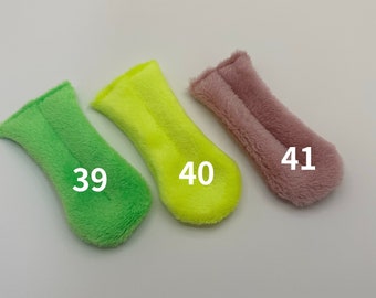 Puede incluir: Tres protectores de dedos de tela afelpada en verde, amarillo y rosa. Los protectores están etiquetados con los números 39, 40 y 41.