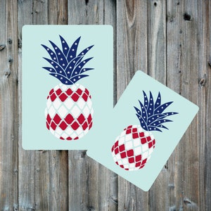 May include: Two pineapple designs with a red, white, and blue color scheme. The pineapples have a checkered pattern with white and red squares. The tops of the pineapples are blue with white stars.