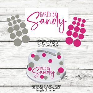 May include: A white cake carrier with a handle and pink and gray polka dots. The text "Baked by Sandy" is in pink script. Includes 2 colors of polka dots: 1", 1.5", and 2". The cake carrier is 4" high.
