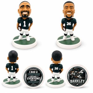 May include: Two football player bobbleheads wearing dark green jerseys with white numbers 1 and 26, white trousers, and holding footballs. The bases are green with white lines. Two circular display discs show text and graphics including Jalen Hurts.