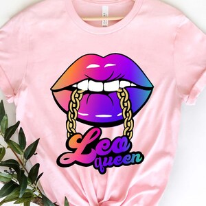 Pu&ograve; includere: Maglietta rosa con una grafica di una bocca arcobaleno con una catena dorata. Il testo "Leo queen" &egrave; sotto la bocca.