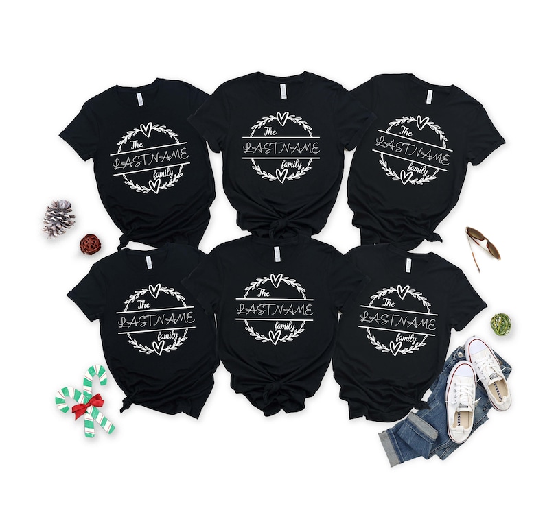 May include: Six black t-shirts with a white circle design featuring the text "The LASTNAME family" on each shirt.