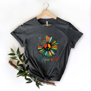 May include: A dark grey t-shirt with a colorful peace sign flower graphic and the text "Hippie soul" printed on the front.