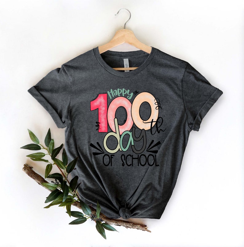 May include: A dark gray t-shirt with a colorful graphic that says "Happy 100th day of school".