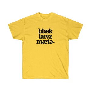 May include: A yellow t-shirt with black text that reads "blaek larvz maeta"