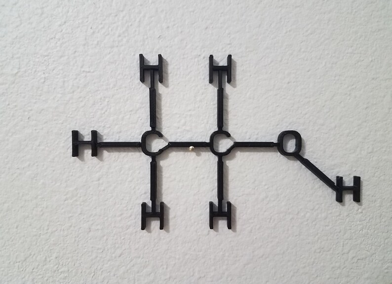 May include: A black plastic model of a chemical molecule with the letters 'H' and 'O' attached to the structure.