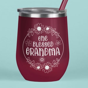 May include: A maroon stainless steel wine tumbler with a white floral design and the text "one blessed grandma".