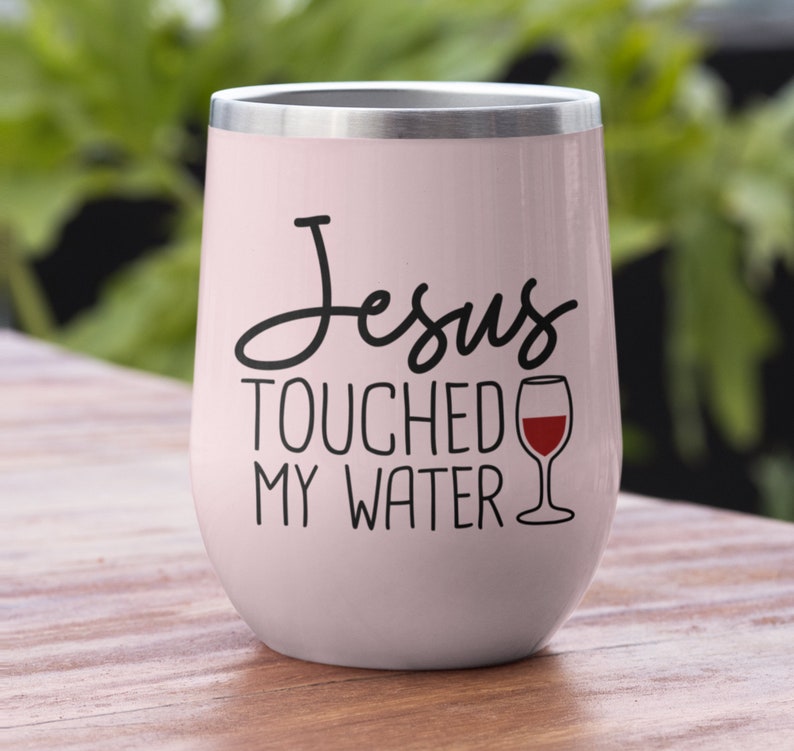 May include: A pink stainless steel tumbler with a black and white graphic that says "Jesus Touched My Water" and a red wine glass graphic.
