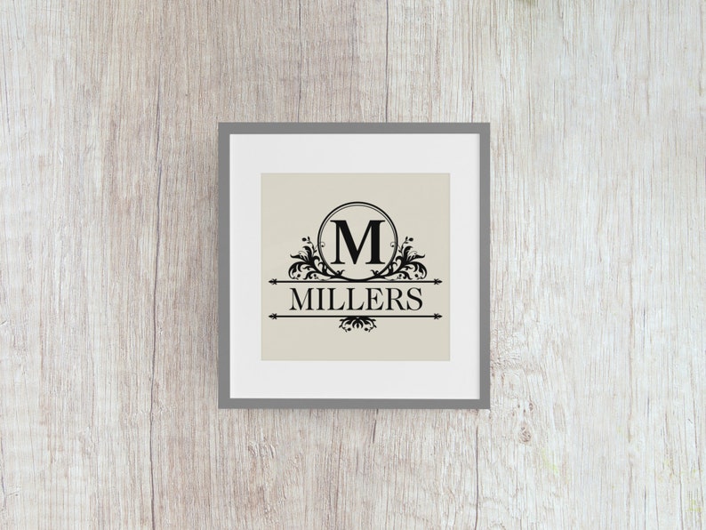 May include: A framed print with a black and white design featuring a decorative circle with the letter "M" inside and the word "MILLERS" below it.