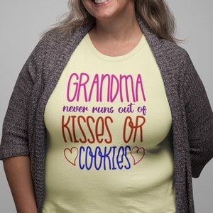 May include: A yellow t-shirt with the text "Grandma never runs out of kisses or cookies" in pink, red, blue, and purple lettering. The text is surrounded by two pink hearts.