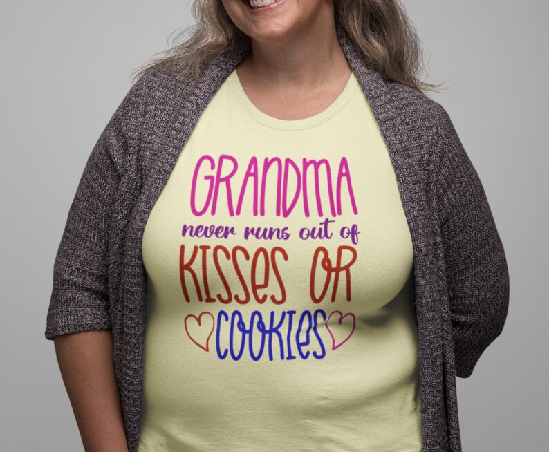 May include: A yellow t-shirt with the text "Grandma never runs out of kisses or cookies" in pink, red, blue, and purple lettering. The text is surrounded by two pink hearts.