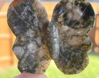 May include: A green and white agate butterfly carving. The butterfly has a detailed design and is polished to a smooth finish.
