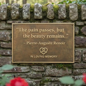 May include: A bronze plaque with the quote "The pain passes, but the beauty remains." by Pierre-Auguste Renoir, set against a stone wall. The plaque includes a pretzel-like symbol and the words "IN LOVING MEMORY". Red roses frame the scene.