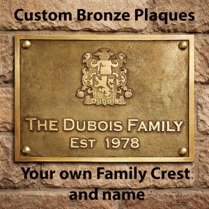 Puede incluir: Placa rectangular de bronce con el texto "Custom Bronze Plaques" en la parte superior y "Your own Family Crest and name" en la inferior. La placa presenta el texto "THE DUBOIS FAMILY EST 1978" y un escudo familiar.