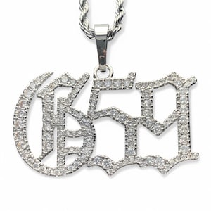 May include: Silver pendant necklace with a large, ornate,  '659' design, fully encrusted with clear cubic zirconia stones.