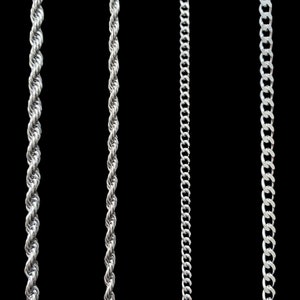 May include: Three silver chains of different styles hanging against a black background. The chains are all made of metal and have a shiny finish.