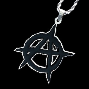 May include: A silver chain necklace with a black pendant featuring a stylized anarchy symbol.