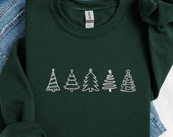 Può includere: Felpa verde scuro con una fila di quattro disegni di alberi di Natale bianchi. Gli alberi sono in stili diversi, da semplici contorni a illustrazioni più dettagliate. La felpa è realizzata in materiale morbido.