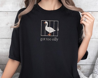 May include: Black t-shirt with a white goose in a cage and the text "got too silly".