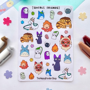 May include: A sheet of stickers featuring characters from Studio Ghibli films. The stickers are colorful and feature characters like Totoro, No Face, and Kiki's Delivery Service. The sheet is titled "Ghibli Friends" and includes the text "The Happy Doodler Shop".