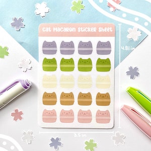 May include: A sticker sheet with 18 cat macaron stickers. The stickers are arranged in rows of three and feature different colors, including purple, green, cream, brown, and pink. The sheet measures 3.5 inches by 4.8 inches.