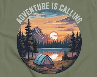 May include: Green t-shirt featuring a graphic of a sunset over a lake with mountains and trees. A tent is pitched on the shore. The text "Adventure is Calling" is in a circle around the graphic.
