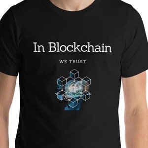 Könnte beinhalten: Schwarzes T-Shirt mit weißem Text "In Blockchain We Trust" und einer Grafik mit einem blauen und weißen geometrischen Design.