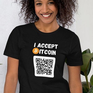Könnte beinhalten: Ein schwarzes T-Shirt mit weißem Text, der "Ich akzeptiere Bitcoin" und ein Bitcoin-Symbol lautet. Unter dem Text befindet sich ein schwarz-weißer QR-Code.