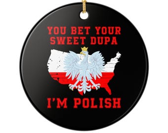 Könnte beinhalten: Runder, schwarzer Keramik-Weihnachtsschmuck mit goldener Aufhängeschlaufe. Das Design zeigt einen stilisierten polnischen Adler über einer rot-weißen Karte der USA mit dem roten Text "YOU BET YOUR SWEET DUPA I'M POLISH".
