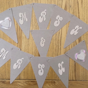 May include: A grey felt banner with silver glitter letters spelling "MR & MRS" with two silver glitter hearts.