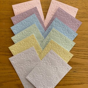 May include: A stack of ten pastel coloured cardstock sheets with a raised embossed pattern of clouds, stars, and crescent moons.