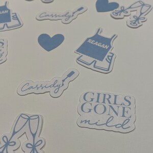 May include: A set of blue and white stickers with various designs, including hearts, champagne glasses, and text that says "Cassidy" and "Girls Gone Mild".