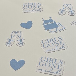 May include: A set of blue and white stickers with various designs, including two glasses of champagne, a heart, a tank top with the word "REAGAN" on it, and three stickers that say "GIRLS GONE MILD".