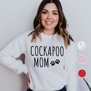 May include: White sweatshirt with the text "Cockapoo Mom" and two paw prints in black.