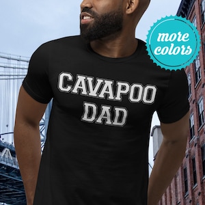 May include: Black t-shirt with white text that reads "Cavapoo Dad".