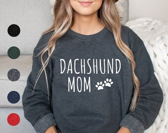 May include: A dark gray sweatshirt with the text "Dachshund Mom" and two white paw prints.