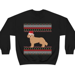 May include: Black Christmas jumper with a red and green pattern. A golden doodle dog wearing a Santa hat is in the centre of the jumper.