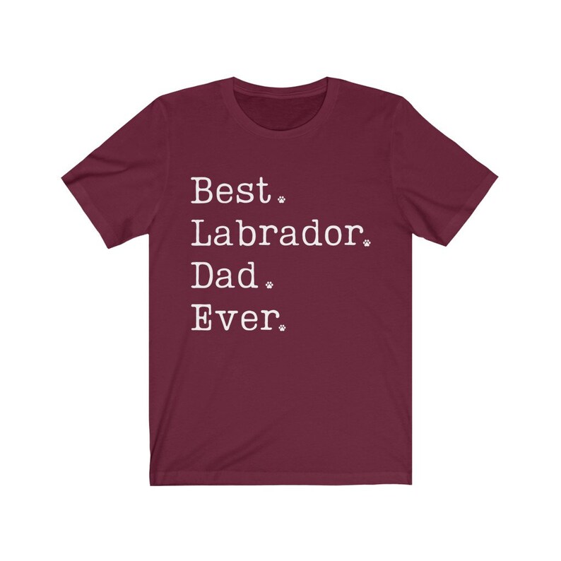 May include: Burgundy t-shirt with white text that reads "Best Labrador Dad Ever."  The text is in a typewriter font and includes paw prints.