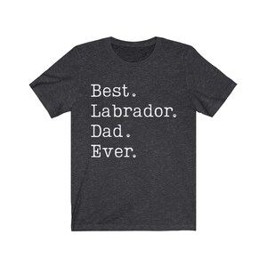 May include: Dark heather grey t-shirt with white text that reads "Best Labrador Dad Ever."  The text is surrounded by small paw prints.