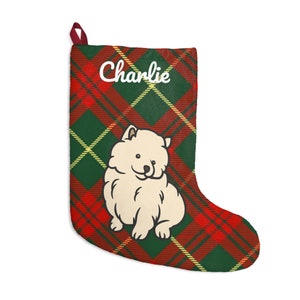 Pode incluir: Meia de Natal com um padrão xadrez vermelho e verde. Um desenho de um cão creme está centrado na meia. O nome "Charlie" está impresso em branco acima do cão.