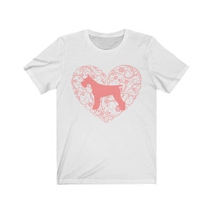 Peut inclure: T-shirt blanc avec une silhouette rose d'un Schnauzer dans un c&oelig;ur rose orn&eacute; de motifs floraux.