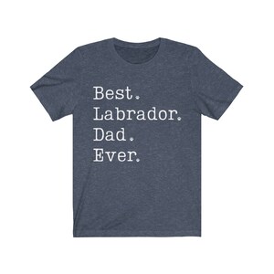 May include: A dark blue t-shirt with white text that reads "Best Labrador Dad Ever."  The text is in a typewriter font and includes paw prints.