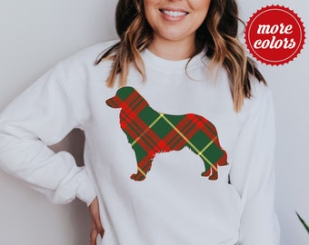 Könnte beinhalten: Weißes Sweatshirt mit einer Hunde-Silhouette im Tartan-Muster in Rot, Grün und Gelb. Das Sweatshirt hat lange Ärmel und einen Rundhalsausschnitt. Ein roter Kreis mit der Aufschrift "more colors" befindet sich oben rechts.