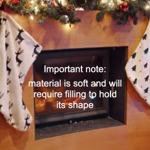 Peut inclure: Deux bas de No&euml;l blancs sont suspendus &agrave; un manteau en bois. L'un a un motif de rennes noirs, l'autre un motif de sapins noirs. Le texte sur l'image dit : &laquo;&nbsp;Remarque importante&nbsp;: le mat&eacute;riau est doux et devra &ecirc;tre rempli pour conserver sa forme&nbsp;&raquo;.